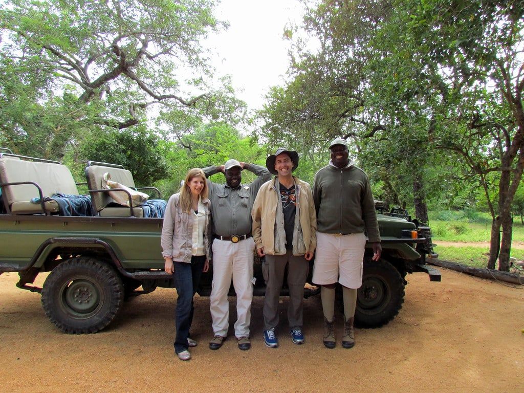 A group stands in front of an open-top safari vehicle in the Greater Kruger National Park area.